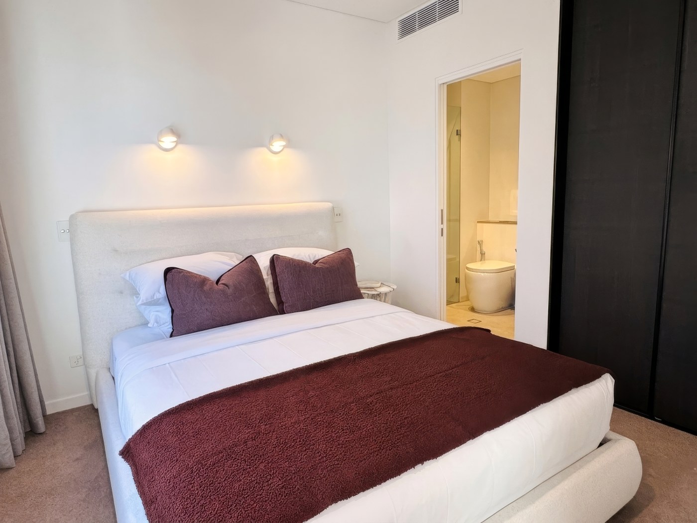 Second bedroom styled in white and stone linen with private ensuite